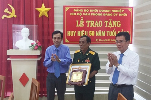 Đồng chí Phan Thành Trung - Bí thư Đảng ủy Khối Doanh nghiệp (bìa trái) trao huy hiệu 50 năm tuổi Đảng cho đảng viên Đoàn Minh Phước, Chi bộ Văn phòng Đảng ủy Khối Doanh nghiệp