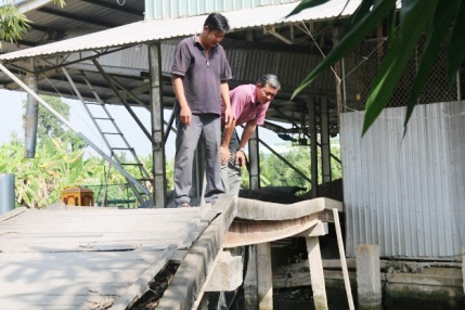 Anh Nguyễn Thanh Nhã (bên trái) cùng ông Nguyễn Văn Nhi - Phó Chủ tịch UBND xã Mỹ Thành Nam khảo sát cầu bắc qua rạch Đìa Dứa dự kiến sẽ cải tạo, nâng cấp