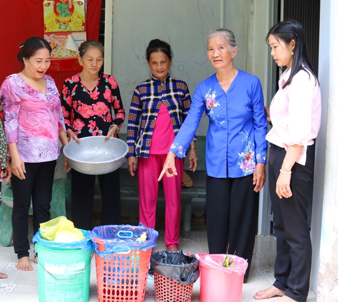 Cô Rồi (áo bà ba xanh) hướng dẫn chị em cách phân loại rác tại nhà.